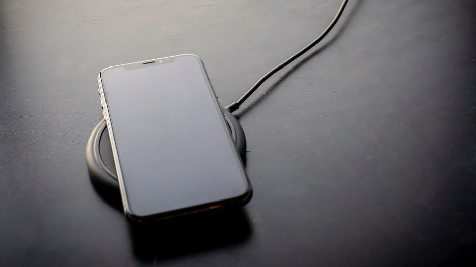 Ein iPhone lädt auf einer Ladestation.