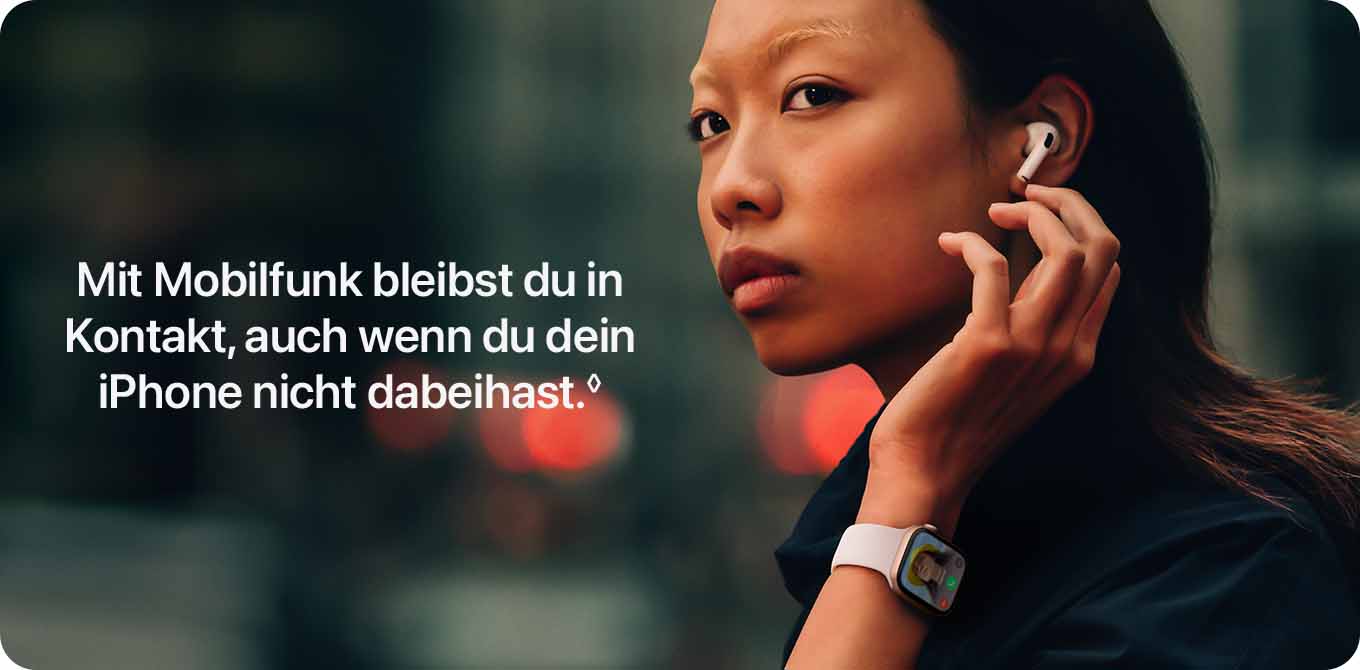 Eine Person mit einem weißen Kopfhörer im Ohr und einer Smartwatch am Handgelenk vor einem verschwommenen Hintergrund.