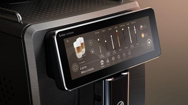 Nahaufnahme einer Kaffeemaschine mit Touchscreen-Display, das Menüoptionen und Einstellungen anzeigt.