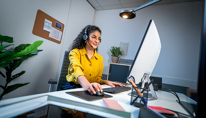 Geschäftsfrau sitzt an ihre Arbeitsplatz vor dem Computer