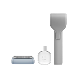 Graue Rasierertasche, daneben ein Rasierkopf und eine kleine Flasche Pflegeöl, nebeneinander aufgestellt.