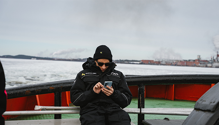 Unter Extrembedingungen: Das brandneue Samsung Galaxy S26. Person in Winterkleidung sitzt auf Boot im Polarmeer mit Galaxy S26 in den Händen.