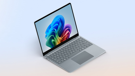 Ein grauer Laptop mit einem farbenfrohen, abstrakten Bild auf dem Bildschirm steht auf einem hellen Hintergrund.