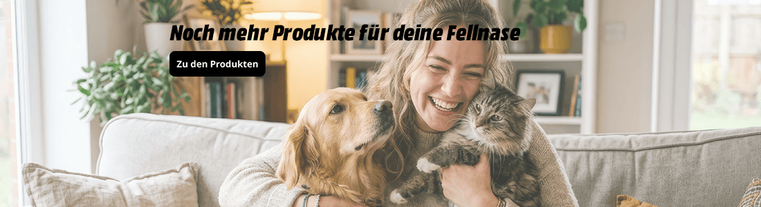 ächelnde Frau sitzt auf einem Sofa und kuschelt mit einem Golden Retriever und einer grau-getigerten Katze. Im Bild steht: „Noch mehr Produkte für deine Fellnase“ sowie der Button „Zu den Produkten“.