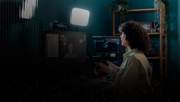 donna dai capelli ricci ripresa mentre guarda uno schermo nella sua cameretta/studio