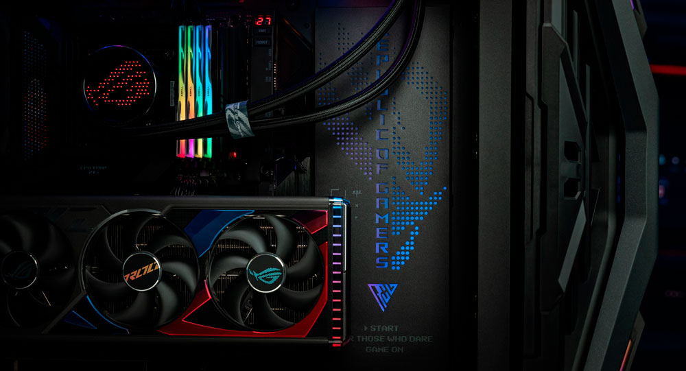 Interno di un computer con ventole, luci multicolore e scritte blu su sfondo scuro.