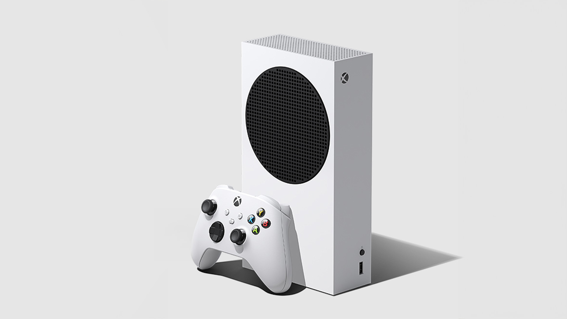 Console Xbox bianca verticale con griglia nera tonda e controller. Sfondo bianco uniforme.