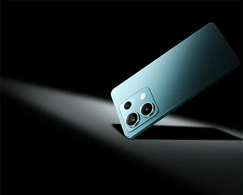 Telefono turchese con tre obiettivi su sfondo nero. La luce mette in risalto la parte posteriore del dispositivo.