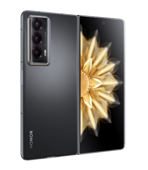 Telefono pieghevole grigio con tripla fotocamera e display con fiore dorato su sfondo nero.