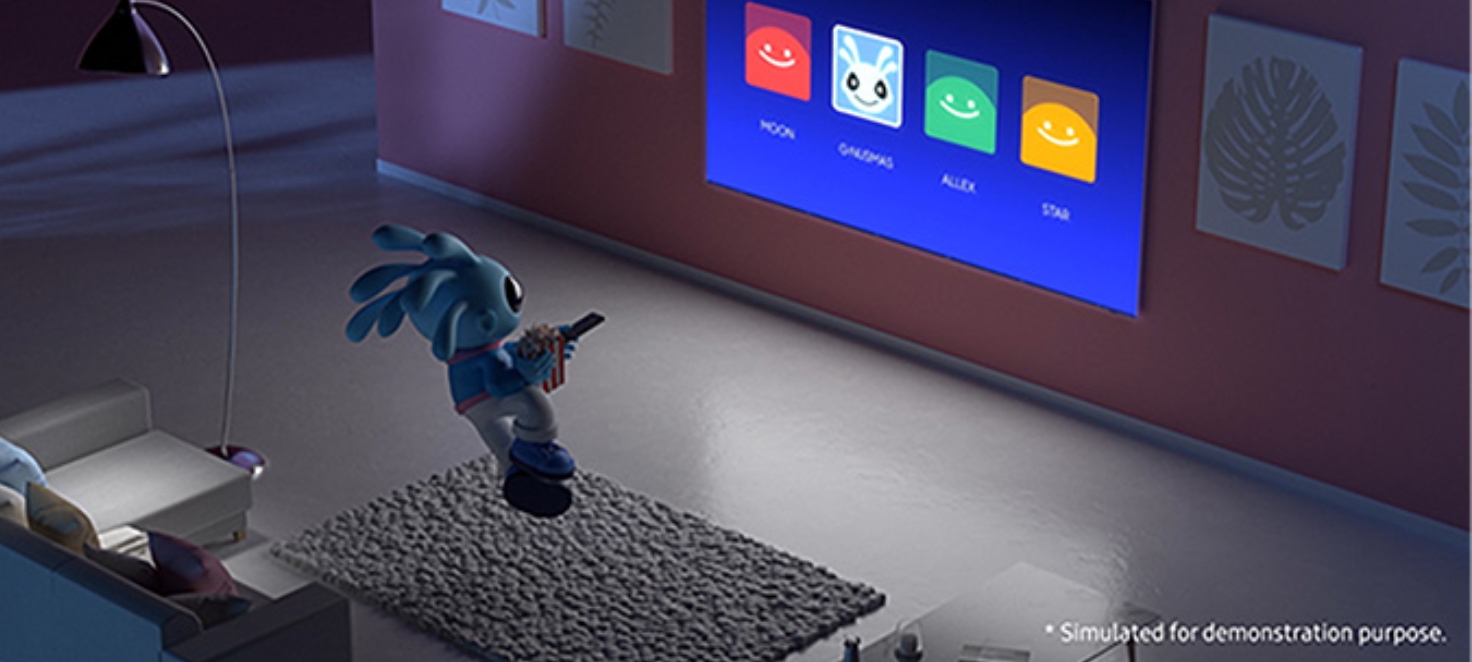 un giocattolino a forma di pesce in un salotto sta usando il telecomando di fronte ad una TV molto grande