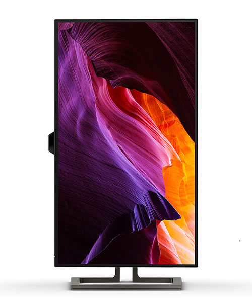 Monitor nero con schermo che mostra forme astratte viola, arancioni e bianche. Il monitor � su una base rettangolare grigia.