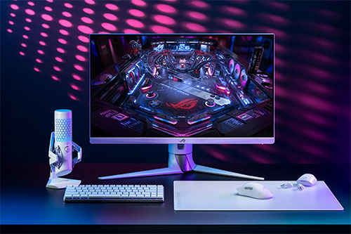Scrivania con monitor acceso, tastiera bianca, microfono su supporto e mousepad con mouse, illuminazione viola e blu.
