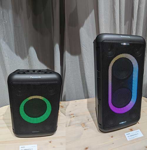 Due casse nere Panasonic su un tavolo di legno. La cassa a destra è più grande e ha un cerchio luminoso multicolore.