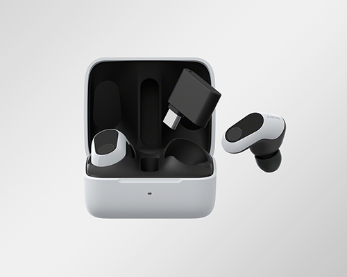 Cuffie bianche e nere con custodia aperta e adattatore USB nero su sfondo bianco.