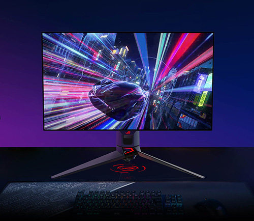 Monitor su scrivania con sfondo animato di citt� futuristica con linee colorate e tastiera in primo piano.