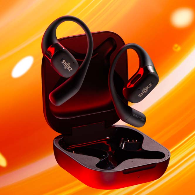 Due auricolari neri Shokz con custodia aperta su sfondo giallo-arancio. Gli auricolari hanno dettagli rossi.