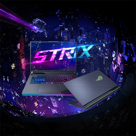 Due laptop grigi mostrano la scritta "STRIX" su uno schermo luminoso, con uno sfondo di citt� futuristica blu e viola.