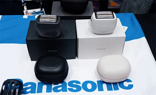 Due rasoi, uno nero e uno bianco, sono esposti su scatole dello stesso colore su un tessuto con logo blu.