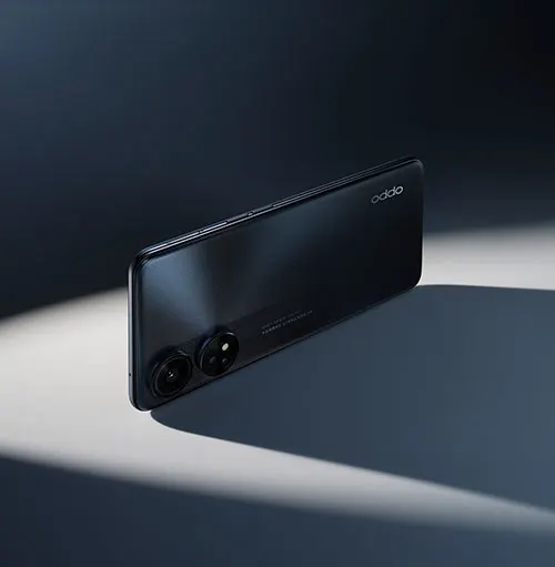 Un telefono nero � appoggiato orizzontalmente su una superficie grigia, con due obiettivi visibili. Sullo sfondo, un muro scuro.