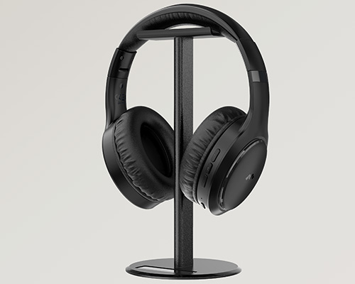 Cuffie nere appese a un supporto nero su sfondo chiaro. Il supporto � metallico con base circolare.