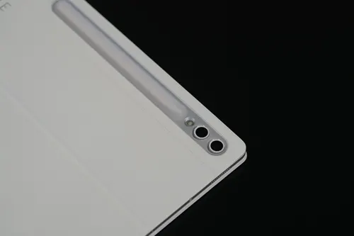 Tablet bianco con due obiettivi della fotocamera in alto a destra, su sfondo nero.