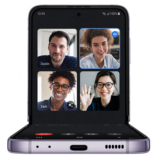 Un telefono mostra quattro persone in una videochiamata. La persona in basso a destra sta salutando con la mano.