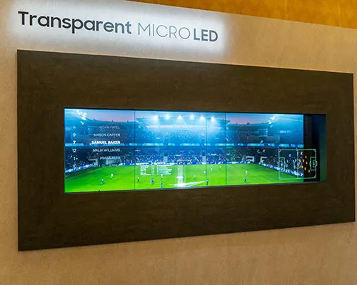 Schermo micro LED trasparente con cornice scura che mostra una partita di calcio in uno stadio.