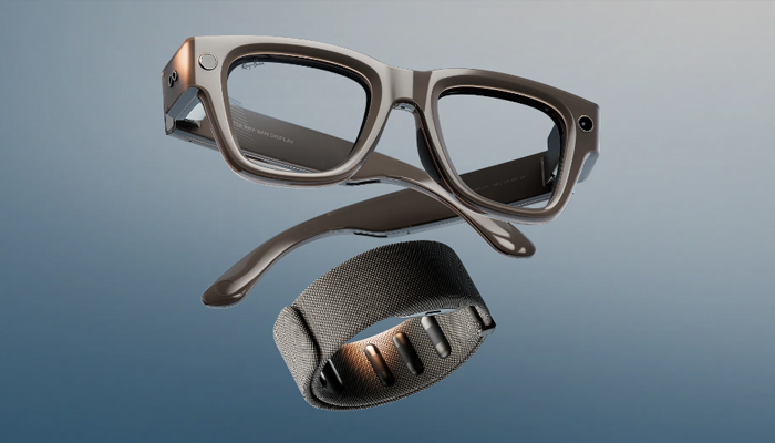 Dettaglio di un paio di occhiali smart neri con display integrato nella lente, mostrato su uno sfondo grigio-azzurro.