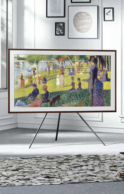 TV con pittura a puntini su cavalletto, su un tappeto a motivi circolari in una stanza.