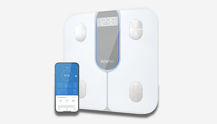 bilancia bianca con vicino un telefono con un'applicazione health aperta