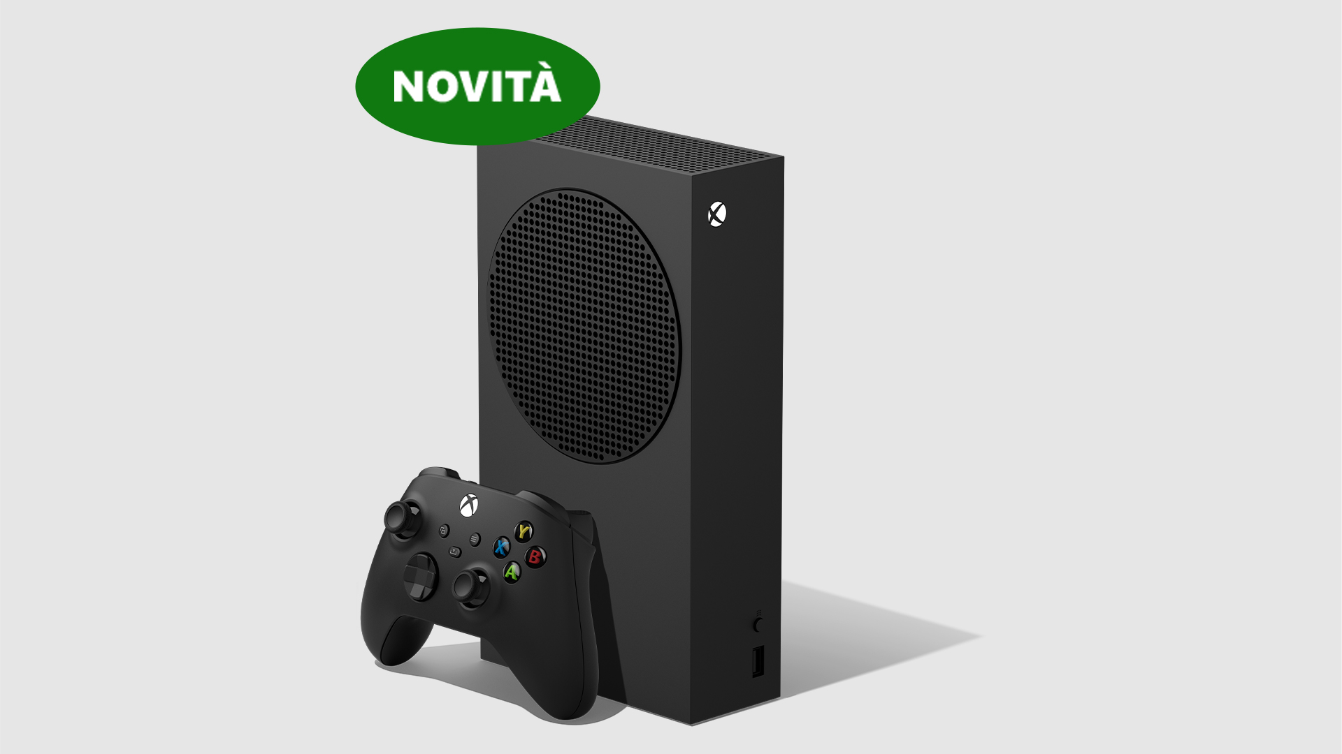 Console Xbox nera con controller, etichetta verde "Novit�" su sfondo chiaro.