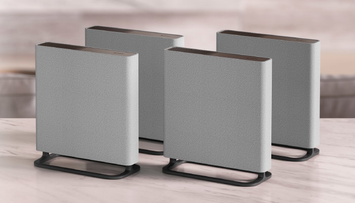 Quattro radiatori grigi su supporti neri su un tavolo. Lo sfondo è sfocato.