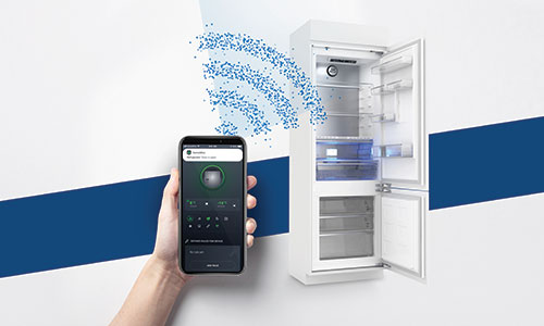 Una mano tiene uno smartphone davanti a un frigorifero bianco aperto. Linee blu suggeriscono connettivit�.