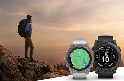 Un escursionista con zaino in montagna guarda il panorama. In primo piano, due orologi smart mostrano mappe e dati.