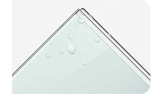 Angolo di un dispositivo elettronico bianco con gocce d'acqua su uno sfondo bianco.