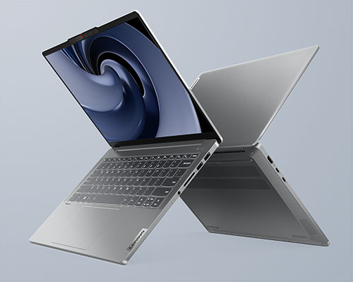 Due computer portatili grigi incrociati su sfondo grigio. Uno � aperto, con schermo acceso e tastiera visibile.