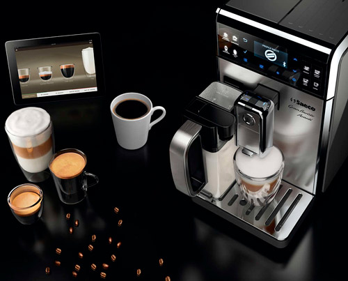 Macchina da caff� automatica in metallo con bevande a base di caff�, chicchi e tablet su sfondo nero.