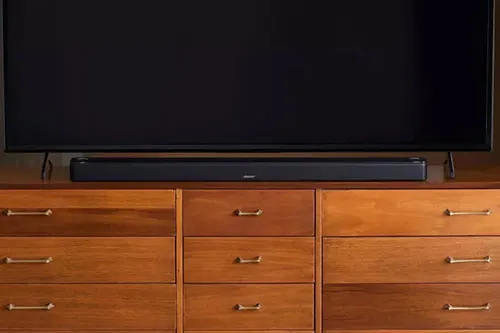 TV nero su com� marrone con nove cassetti e altoparlante nero sotto.