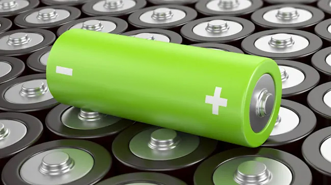 Una batteria verde con simboli bianchi su un gruppo di batterie piatte grigie e argentate.