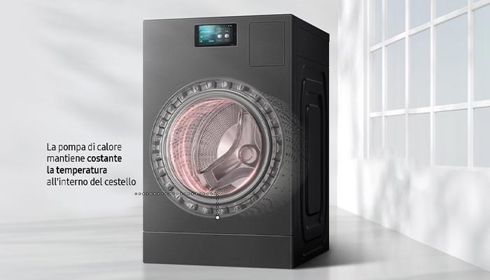 Lavatrice grigia con display digitale e oblò trasparente che mostra il cestello interno. Sullo sfondo, finestra a griglia bianca.