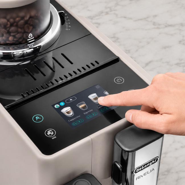 una mano digita sulla macchina da caffè