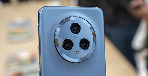 Retro di telefono blu con tre fotocamere nere disposte in cerchio argentato. La scritta "50X" � visibile al centro.