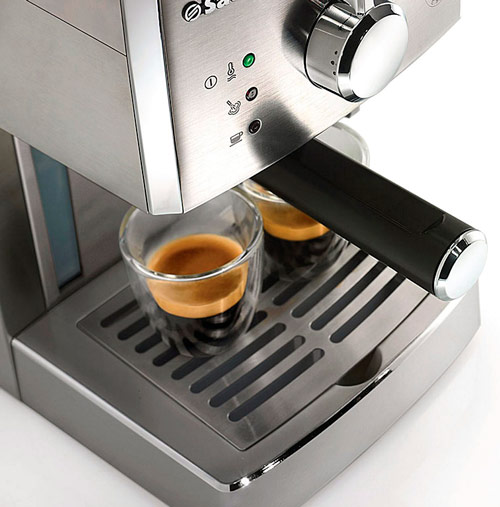 Macchina da caff� in acciaio con due tazzine di caff� espresso sul vassoio raccogligocce.