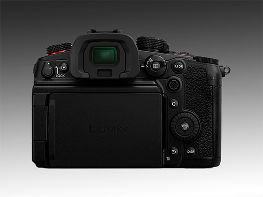 Vista posteriore di una fotocamera nera con pulsanti, mirino e schermo orientabile.