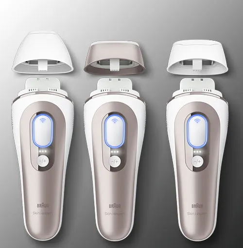 Tre dispositivi IPL bianchi e beige con coperchi rimovibili su sfondo grigio sfumato.