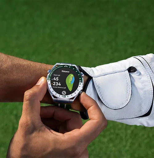 Un uomo guarda un orologio sportivo con schermo verde e blu. Indossa un guanto bianco. Sfondo verde sfocato.