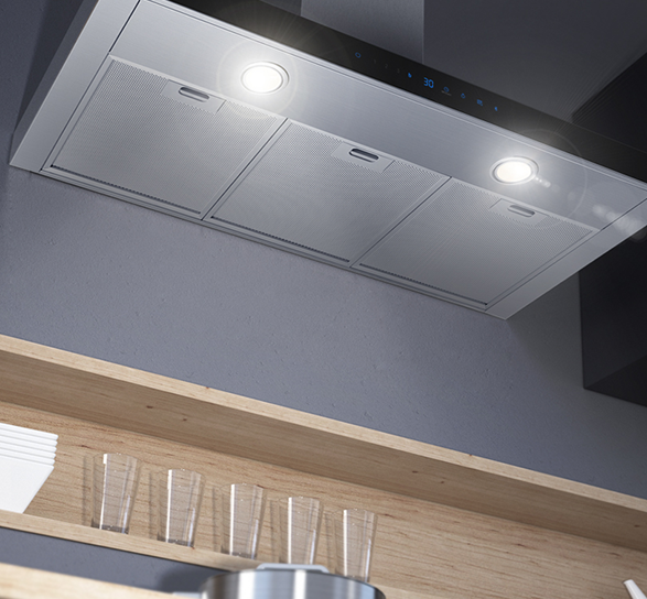 Cappa d'acciaio con luci sopra uno scaffale di legno. Sul ripiano, bicchieri e contenitori chiari. Il muro � grigio.