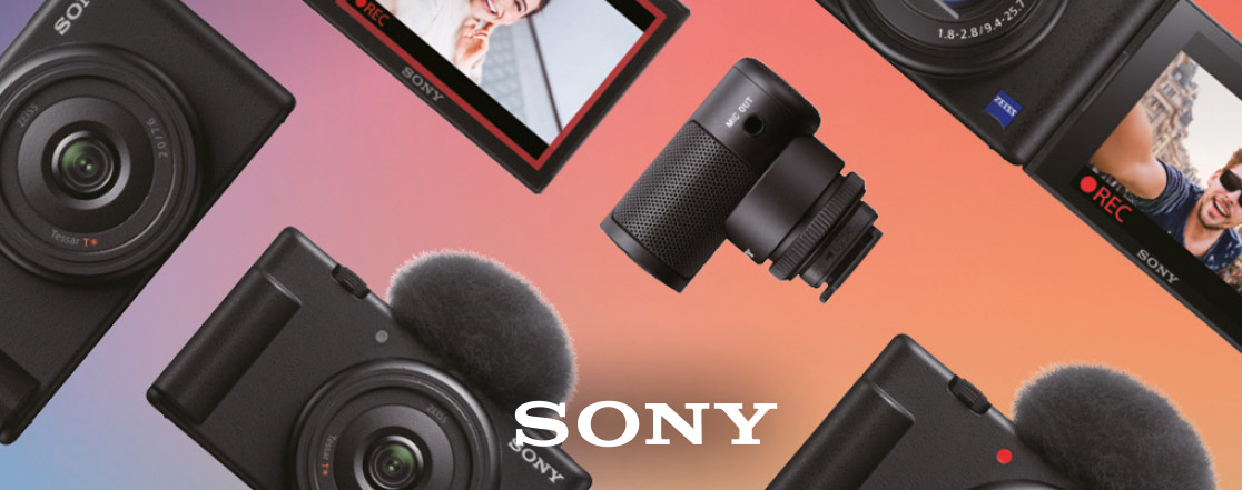 Diverse fotocamere Sony su sfondo sfumato rosa e blu, con microfono e schermi LCD che mostrano riprese.