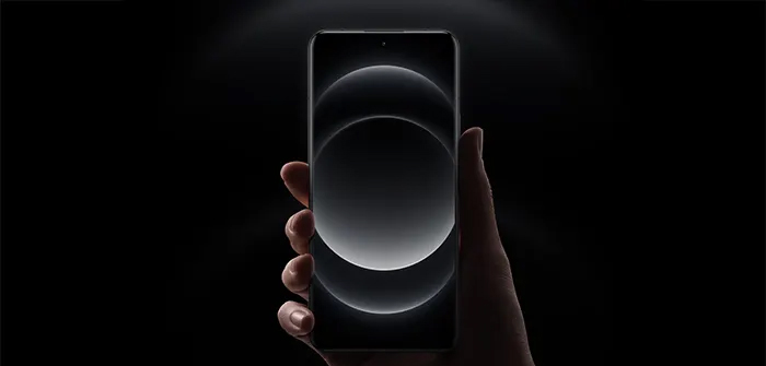 Una mano tiene un telefono. Lo schermo mostra cerchi grigi su sfondo nero.