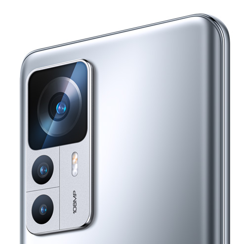 Vista ravvicinata del retro di un telefono argentato con un blocco fotocamera rettangolare che ospita tre obiettivi.